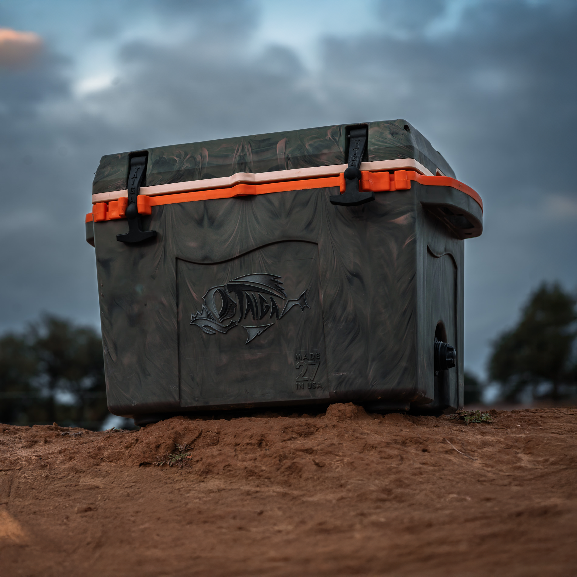 Taiga 27Qt camo and orange cooler on red Texas dirt — built in Mesquite, Texas